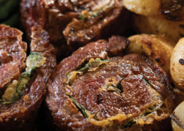 rollos-de-vacio-con-espinaca-y-roquefort en un plato con papas cambray y espárragos